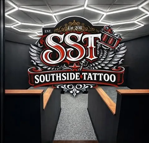 The entrance of the Southside Tattoo studio on Tongarra Rd, with the illuminated SST wall sign under a hexagonal light ceiling