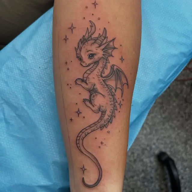 Fine line dragon tattoo winding down a forearm